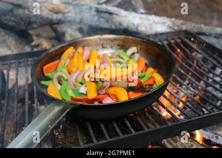 Gros plan de légumes frits dans une casserole sur le feu de camp Banque D'Images