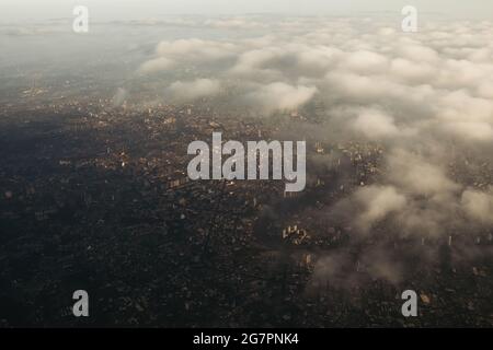 La vue plongeante de la ville de Bangkok, prise à partir d'un avion qui vole le matin avec une couleur de lever du soleil réchauffée et un peu d'ombre des nuages photo peut avoir n Banque D'Images