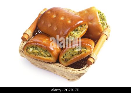 Petits tourtes avec légumes et légumes dans un panier en osier sur fond blanc Banque D'Images