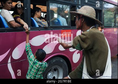 19.01.2014, Yangon, Myanmar, Asie - ON voit UN homme avec un avant-bras manquant mendier avec son fils dans une rue au centre de l'ancienne capitale. Banque D'Images