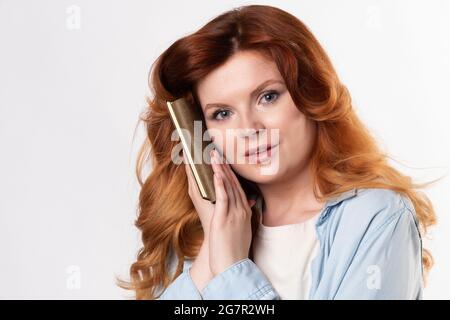 Ginger femme avec le cuir bloc-notes posin comme modèle en studio comme écrivain ou gestionnaire Banque D'Images