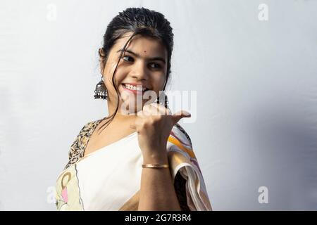 Isolé sur fond blanc une femelle indienne en saree montrant un espace vide à sa gauche sur fond blanc Banque D'Images