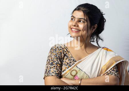 Isolée sur fond blanc une femme indienne en saree avec visage souriant regardant latéralement à vide espace pour la publicité Banque D'Images