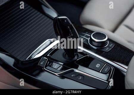 Détails de l'habitacle du poste de pilotage. Changement de vitesse automatique dans une voiture moderne et chère. Intérieur de la voiture avec vue rapprochée de la transmission automatique. Banque D'Images