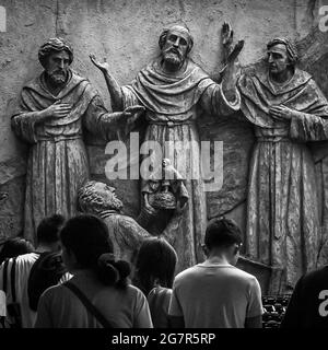 Prise de vue verticale en niveaux de gris de personnes dans la basilique Minore del Santo Nino de Cebu aux Philippines Banque D'Images