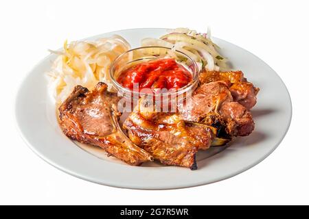 un kebab d'agneau sur un os repose sur une assiette sur un fond blanc isolé Banque D'Images