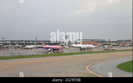 DON-MUEANG, BANGKOK - Mai 2018 : vue sur l'aéroport international Don-mueang, parking pour avions à la baie de stationnement. Service passagers en bus depuis la porte d'autobus. Banque D'Images