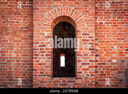 L'embrasure dans le mur d'un ancien château en brique rouge Banque D'Images