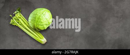 Bouquet de branches de céleri et chou vert isolés sur fond de bannière en béton. Vue de dessus Banque D'Images