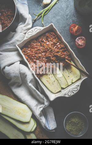 Préparation de la cuisson de courgettes lasagnes bolognese sur table de cuisine sombre avec ingrédients. Alimentation saine. Vue de dessus Banque D'Images