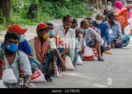 Les personnes à faible revenu reçoivent des produits alimentaires d'urgence fournis par l'armée du Bangladesh pendant l'isolement national afin de freiner la propagation du coronavirus (COVID-19) Banque D'Images