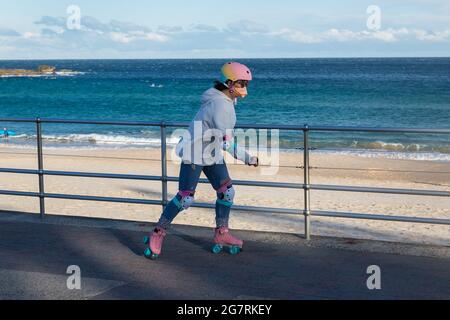 Sydney, Australie. Vendredi 16 juillet 2021. Une femme sur des patins à roulettes qui longe la promenade de Bondi Beach. Les restrictions de verrouillage ont été renforcées et étendues en raison de la variante Delta des cas COVID-19 à Sydney, dans les montagnes bleues et sur la côte centrale. L'exercice est limité à deux personnes par groupe et les gens doivent se remian dans un rayon de 10km de leur maison. Crédit : Paul Lovelace/Alamy Live News Banque D'Images