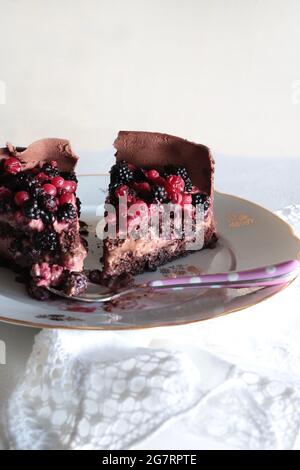Morceaux de délicieux gâteau au chocolat maison frais avec baies sur fond blanc. Banque D'Images