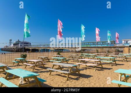 Bournemouth, Dorset, Royaume-Uni. 16 juillet 2021. Le Sunset Beach Club ouvre sur la plage de Bournemouth pour le déjeuner et propose un nouveau restaurant et un bar de plage, inspirés des îles Baléares et de Bali. Géré par l'équipe Aruba, il se tiendra jusqu'à la fin septembre et ouvrira à 12 h tous les jours de la semaine pendant les mois d'été, proposant des plats, des bières froides, des cocktails et des DJ. Crédit : Carolyn Jenkins/Alay Live News Banque D'Images