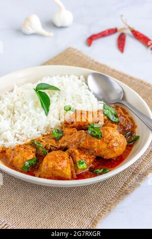 Curry de poulet au riz dans un bol sur fond blanc aliment vertical photo Banque D'Images