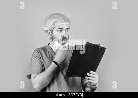 une infirmière vérifie le film radiographique à l'hôpital. maladie mortelle. l'homme regarde le roentgen. Radiologiste tenir la radiographie. Chirurgien médecin examine le cliché radiographique. X Banque D'Images