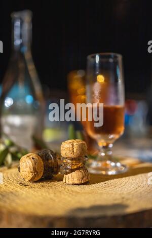 Un verre de champagne avec deux corks cassés est posé sur une planche en bois sur la table Banque D'Images
