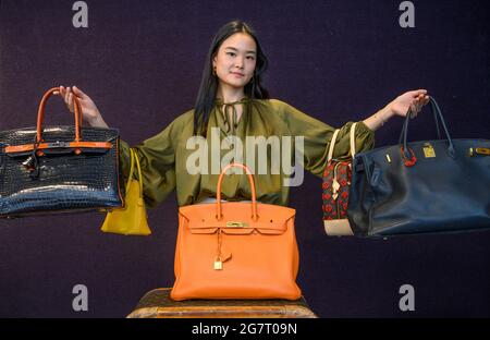 Bonhams, Londres, Royaume-Uni. 16 juillet 2021. La vente de mode et de sacs à main de designer (qui a lieu le 20 juillet) comprend le Black Togo Birkin 35 de Jane Birkin, Hermès, c. 1999. Avec une lettre d’authenticité signée de Jane Birkin et d’Anno’s Africa, et une copie d’une lettre écrite par Jane Birkin, détenue par Bonhams Catalogr Suzi Yang. Estimation: £15,000-20,000: Dans la main gauche de Suzi, a Black and Orange H Brily Crocodile Birkin35, Hermès, édition limitée 2007, estimation: £18,000-22,000. Au centre se trouve un Orange Togo Birkin 35, Hermès, c. 2011, estimation: £4,000-6,000. Crédit : Malcolm Park/Alay Live News Banque D'Images