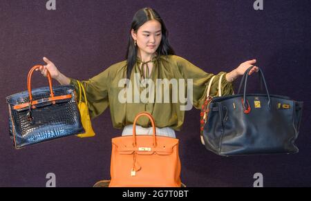 Bonhams, Londres, Royaume-Uni. 16 juillet 2021. La vente de mode et de sacs à main de designer (qui a lieu le 20 juillet) comprend le Black Togo Birkin 35 de Jane Birkin, Hermès, c. 1999. (À droite) avec une lettre d’authenticité signée de Jane Birkin et Anno’s Africa, et une copie d’une lettre écrite par Jane Birkin, détenue par Bonhams Catalogr Suzi Yang. Estimation: £15,000-20,000: À la gauche de Suzi, a Black and Orange H Brily Crocodile Birkin35, Hermès, édition limitée 2007, estimation: £18,000-22,000. Au centre se trouve un Orange Togo Birkin 35, Hermès, c. 2011, estimation: £4,000-6,000. Crédit : Malcolm Park/Alay Live News Banque D'Images