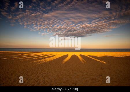 Ombres au coucher du soleil des cabanes de plage sur la plage à Southwold dans Suffolk, Angleterre Royaume-Uni Banque D'Images