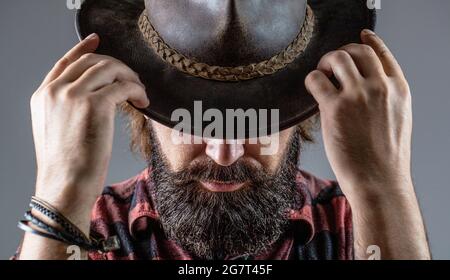 Cowboys en chapeau. Jolie macho barbu. Cow-boys non rasés. Cow-boy américain. Chapeau de cowboy en cuir. Portrait d'un jeune homme portant un chapeau de cow-boy Banque D'Images