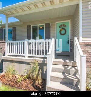 Cadre carré extérieur d'une maison avec briques, porche surélevé et fenêtres à double vitrage Banque D'Images