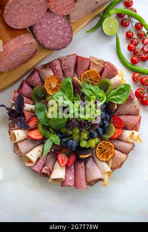 Assiette à viande sur fond de bois blanc. Ensemble de salami. Coupes froides de différents types de viande. Plateau de set antipasti. Plat de collation à la viande. Vue de dessus Banque D'Images