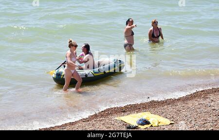 Brighton Royaume-Uni 16 juillet 2021 - Brighton Beach est occupé par une chaude journée ensoleillée comme le temps chaud est prévu pour se poursuivre au cours des prochains jours en Grande-Bretagne avec des températures qui devraient atteindre les 20 hauts au cours du week-end : crédit Simon Dack / Alamy Live News Banque D'Images