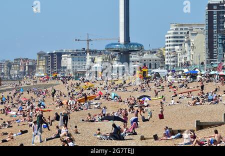 Brighton Royaume-Uni 16 juillet 2021 - Brighton Beach est occupé par une chaude journée ensoleillée comme le temps chaud est prévu pour se poursuivre au cours des prochains jours en Grande-Bretagne avec des températures qui devraient atteindre les 20 hauts au cours du week-end : crédit Simon Dack / Alamy Live News Banque D'Images