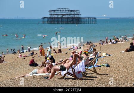 Brighton Royaume-Uni 16 juillet 2021 - Brighton Beach est occupé avec des baigneurs de soleil par une chaude journée ensoleillée comme le temps chaud est prévu pour se poursuivre dans les prochains jours en Grande-Bretagne avec des températures qui devraient atteindre les 20 hauts au cours du week-end : Credit Simon Dack / Alamy Live News Banque D'Images