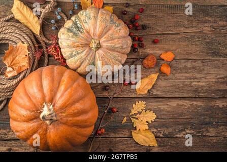 Feuilles de citrouille sèches sur un fond en bois marron. Arrière-plan de l'automne. Banque D'Images