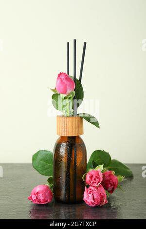 Bouteille à diffuseur humide avec bâtonnets et roses roses Banque D'Images