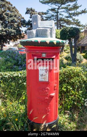 Les boîtes postales rouges Royal Mail avec des hauts en laine tricotés à la main en appréciation des principaux travailleurs à travers la pandémie de Covid 19 Banque D'Images