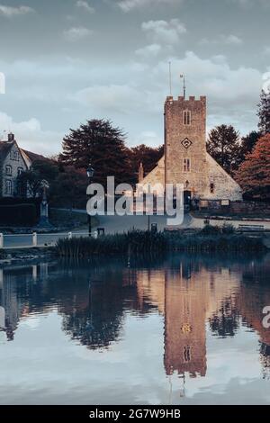 L'église de Buriton dans le Hampshire se reflétant sur l'étang du village Banque D'Images