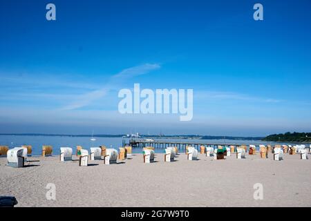 Des rangées de chaises de plage en osier colorées à la plage Banque D'Images