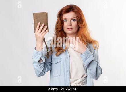 Ginger femme avec le cuir bloc-notes posin comme modèle en studio comme écrivain ou gestionnaire Banque D'Images