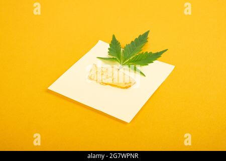 teneur élevée en thc, morceaux de cire de cannabis jaune doré et feuille verte, concentré de marijuana. Banque D'Images