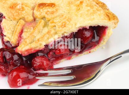 Une tranche de tarte aux cerises garnie de cerises Morello sucrées et juteuses et de pâte à croûte courte. Banque D'Images