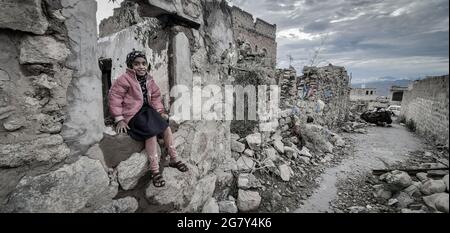 Taiz   Yémen   03 mai 2021 : le sourire d'une fille assise sur les décombres de maisons détruites à cause de la guerre à Taiz, Yémen Banque D'Images