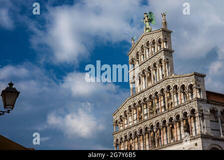 Saint Micheal dans l'église Foro magnifique façade romane parmi les nuages avec l'ancien lampadaire, érigée au XIIIe siècle dans le centre de Lucques Banque D'Images