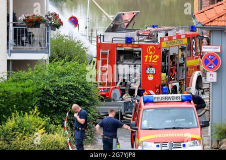 Hattingen, NRW, Allemagne. 16 juillet 2021. Les pompiers, ainsi que de nombreux bénévoles, pompent l'eau des sous-sols, débassent les débris et aident les résidents à avoir besoin d'aide. La Ruhr a inondé son remblai, ses champs et de nombreux jardins, sous-sols et propriétés près de la ville de Hattingen dans le district de la Ruhr en Rhénanie-du-Nord-Westphalie. Le NRW a été frappé par de terribles inondations, suite à de fortes pluies au cours des derniers jours. Plus de 80 000 personnes sont mortes jusqu'à présent lors des inondations en Allemagne. Credit: Imagetraceur/Alamy Live News Banque D'Images