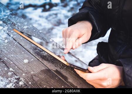 l'homme bascule à travers les photos sur une tablette tout en étant assis à une table en bois Banque D'Images