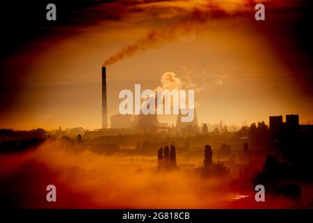 Usine avec cheminées et fumée dans l'orange Banque D'Images