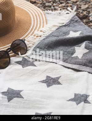Concept été avec chapeau de paille et lunettes de soleil sur serviette de plage. Gros plan. Banque D'Images
