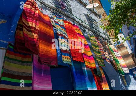 CHEFCHAOUEN, MAROC - 31 août 2018 : tissus et foulards colorés dans une rue étroite de la ville de Chefchaouen, Maroc Banque D'Images