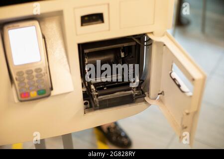 Remplacement de la bande de la caisse. Lecteur de ruban pour reçus. Équipement de lecture de données. Installation d'une bobine de papier. Banque D'Images