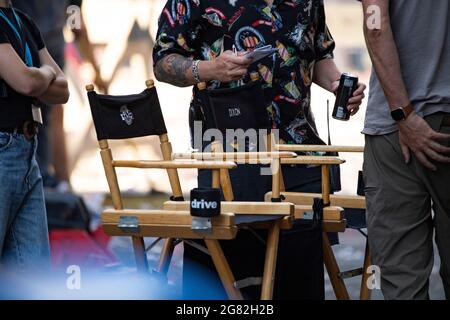 Glasgow, Écosse, Royaume-Uni. 16 juillet 2021. PHOTO : les chaises des directeurs ont été remplies pour la journée. Jour 4 du tournage du film hollywoodien à succès d'Indiana Jones 5. Les scènes d'aujourd'hui disent une parade de ticker avec des bandes de marchage, des foules de foudroyantes, la presse et les astronautes de retour dans une scène américaine de New York 1959. Les rues sont décorées d'étoiles et de bandes drapeaux et de banderoles et le Harrison Ford double a été vu à cheval de retour dans les rues de Glasgow. Crédit : Colin Fisher/Alay Live News Banque D'Images