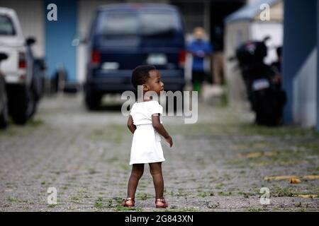 Tegucigalpa, Honduras. 16 juillet 2021. Une fille marche à travers les installations du centre de migration. Plus de 120 migrants, principalement d'origine haïtienne et un petit nombre de Cubains, sont arrivés hier dans la capitale Tegucigalpa pour poursuivre leur voyage migratoire vers les États-Unis. Après avoir été entrés dans le territoire hondurien, ils ont arrêté pendant quelques heures leur marche dans l'un des bureaux de l'Institut national des migrations (INM) où ils ont reçu un comportement sûr pour pouvoir traverser le Honduras. (Credit image: © Milo Espinoza/ZUMA Press Wire) Banque D'Images