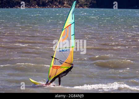 Homme australien sur son planche à voile à Pittwater à Sydney, en Australie Banque D'Images