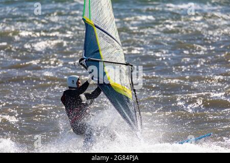 Homme australien sur son planche à voile à Pittwater à Sydney, en Australie Banque D'Images